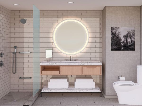 A modern bathroom with a round lit mirror, marble sink, shower area, and toilet, featuring neutral tones and a black and white wall photo.