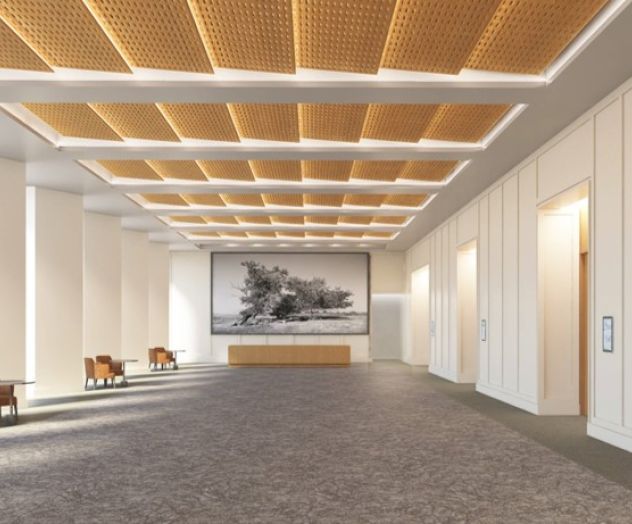 A spacious, modern interior features a wood-accented ceiling, carpeted floor, chairs along the wall, and a large framed artwork on display.